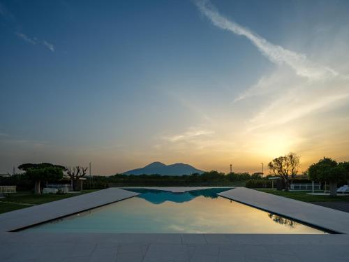 a swimming pool with a sunset in the background at Secret Garden Resort & Spa in Palma Campania