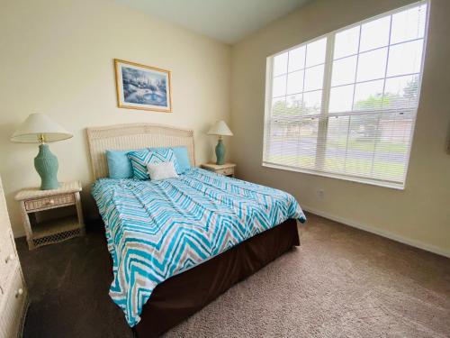 1 dormitorio con cama y ventana grande en Ezras Vacation Home at Southern Dunes, en Haines City