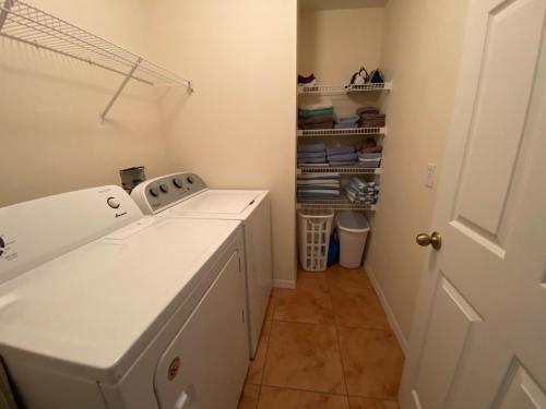lavadero blanco con lavadora y secadora en Ezras Vacation Home at Southern Dunes, en Haines City