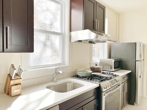 uma cozinha com um lavatório e um fogão forno superior em 4 Bedroom Condo At Harvard Square and Harvard University em Cambridge