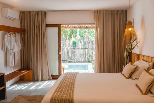 a bedroom with a bed and a large window at Quadrado Pousada in São Miguel dos Milagres