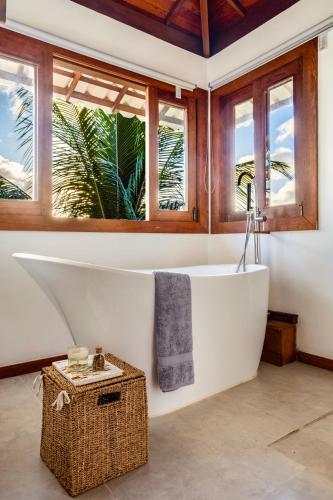 a bath tub in a bathroom with windows at Casa Beija Flor - Taipu de fora - Marau in Marau