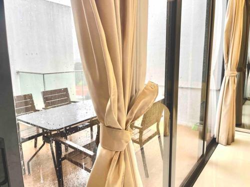 Cette chambre dispose d'une fenêtre avec une table et une chaise. dans l'établissement Centralize Stylish Loft Apartment Near MRT 市中心全景屋, à Singapour