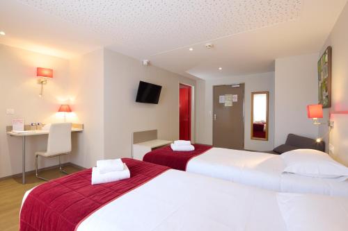 a hotel room with two beds and a desk at Hôtel Saint Laurent in Nogent-sur-Seine