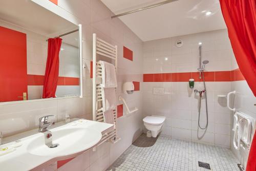a bathroom with a sink and a toilet and a shower at Hôtel Saint Laurent in Nogent-sur-Seine