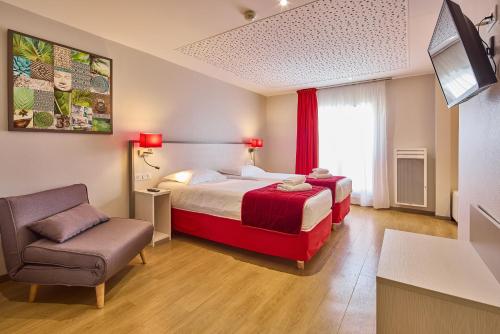 a hotel room with a bed and a chair at Hôtel Saint Laurent in Nogent-sur-Seine