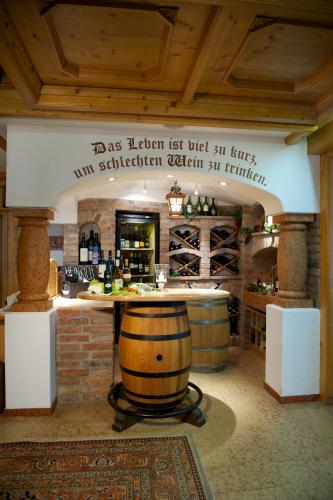 a wine tasting room with a barrel and a bar at Hotel Neuhaus in Saalbach Hinterglemm