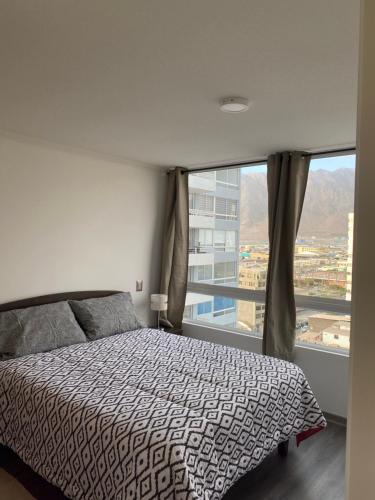 1 dormitorio con cama y ventana grande en Edificio Lynch Iquique, en Iquique