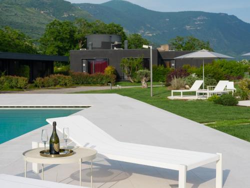 a bottle of wine on a table next to a pool at Secret Garden Resort & Spa in Palma Campania