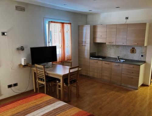 a room with a kitchen and a table with chairs at Residence Stefania Cavasso Nuovo in Cavasso Nuovo