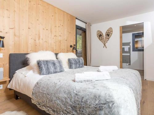een slaapkamer met een groot bed en houten wanden bij Chamonix Praz Vue Mt Blanc Piscine in Chamonix-Mont-Blanc