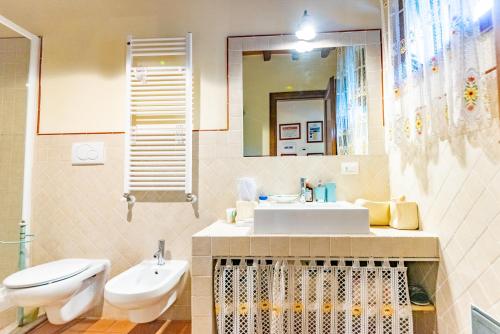 ein Badezimmer mit einem Waschbecken, einem WC und einem Spiegel in der Unterkunft Casa Marlèn in Collazzone
