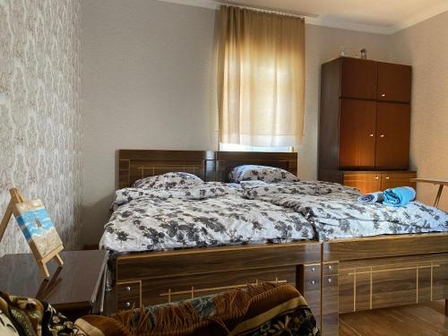 a bedroom with a large bed and a dresser at Aloha House in Akhaltsikhe