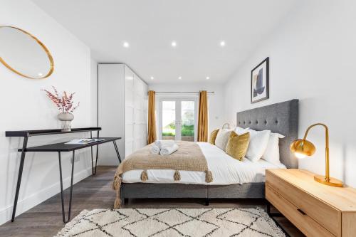 a bedroom with a bed and a desk and a mirror at SERCASA - The Hyde - Hendon Station in The Hyde
