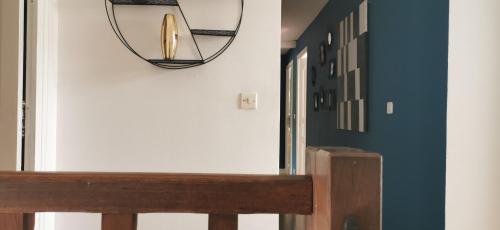 un couloir avec un éclairage circulaire sur le mur dans l'établissement Séjour cosy entre Beauval et Center Parc, à Selles-sur-Cher