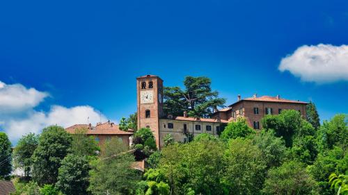 a building with a clock tower on top of trees at Viavai in Casalborgone