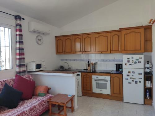 a kitchen with wooden cabinets and a couch in a room at Casa Joleen 1 in Villamartin
