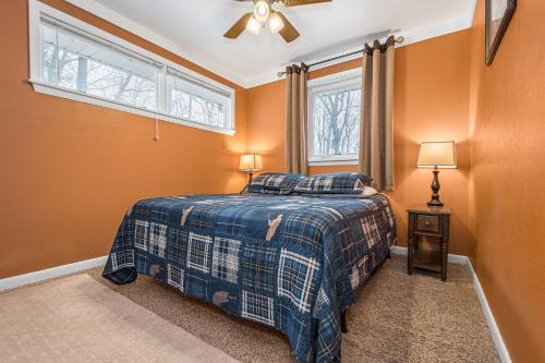 een slaapkamer met oranje muren en een bed en een raam bij Summer Days Winter Nights in Swanton