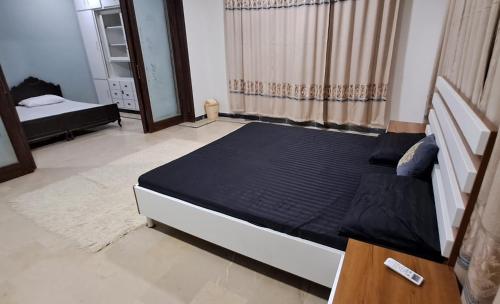 a bedroom with a bed in a room with a window at Islamabad Airport Guest House Free Pick-up and Drop off Available 24 Hours in Islamabad