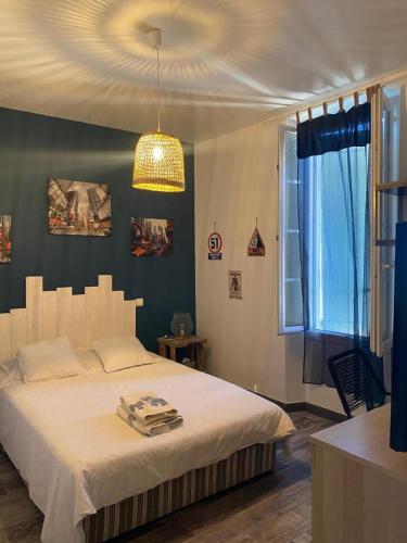 une chambre avec un grand lit et un lustre dans l'établissement Appartement avec jardin en ville, à LʼIsle-sur-la-Sorgue