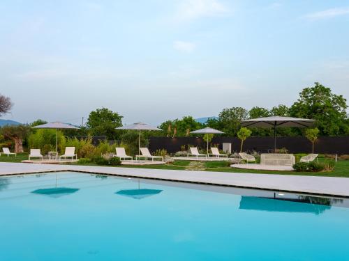 a large swimming pool with chairs and umbrellas at Secret Garden Resort & Spa in Palma Campania