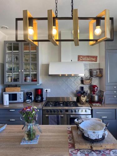 - une cuisine avec une cuisinière et une table avec un bol dans l'établissement Appartement avec jardin en ville, à LʼIsle-sur-la-Sorgue