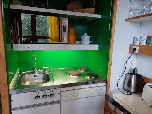 - une cuisine verte avec évier et cuisinière dans l'établissement Duplex pour 5 personnes proche des pistes et commerces, balcon, TV, non-fumeur - FR-1-411-197, à Arc 1800