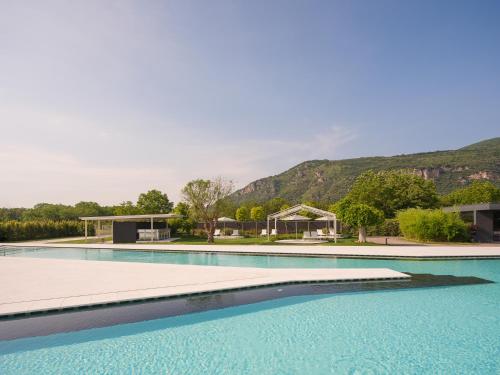 a large swimming pool with a mountain in the background at Secret Garden Resort & Spa in Palma Campania