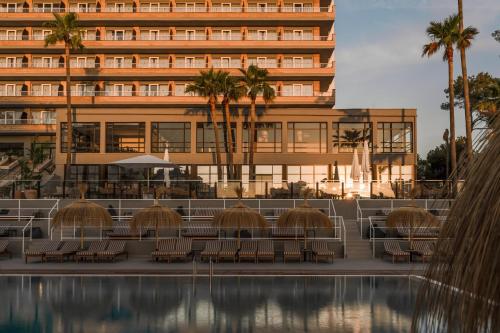 ein Hotel mit Tischen und Stühlen vor einem Gebäude in der Unterkunft Cooks Club Calvia Beach - Adults Only in Magaluf