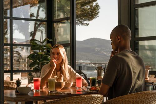 a man and woman sitting at a table in a restaurant at Cooks Club Calvia Beach - Adults Only in Magaluf
