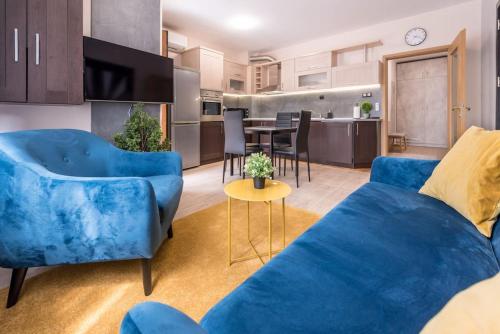 a living room with blue couches and a kitchen at Stylish apartment on Bregalnitsa str in Varna City