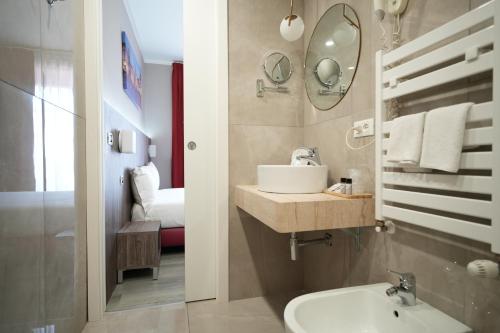bagno con lavandino e specchio di Hotel Urbani a Torino