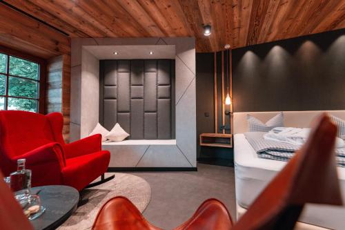 a living room with a red chair and a bed at Landgasthof & Hotel beim Lipp in Roßhaupten