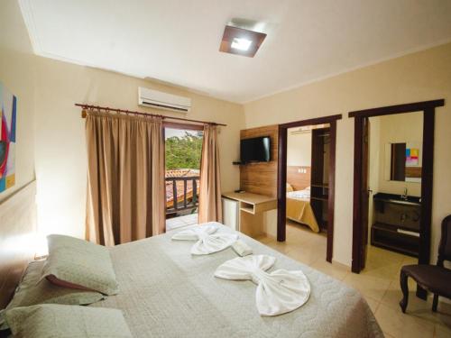 Habitación de hotel con cama y balcón en Chamame - Pousada em Bonito, en Bonito