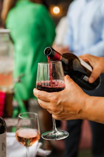 a person pouring wine into a wine glass at Mama Shelter Bordeaux Centre in Bordeaux