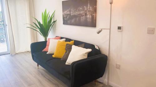 a black couch with colorful pillows in a living room at Bridgefield Apartment in Ashford