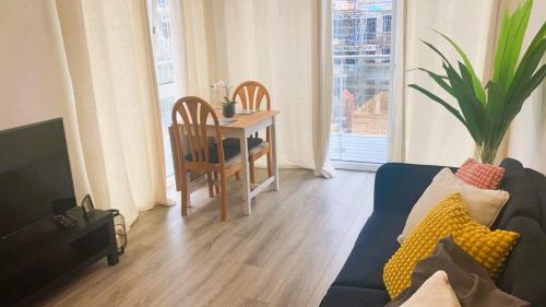a living room with a blue couch and a table at Bridgefield Apartment in Ashford