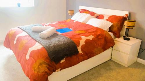 a bedroom with a bed with a colorful comforter at Bridgefield Apartment in Ashford