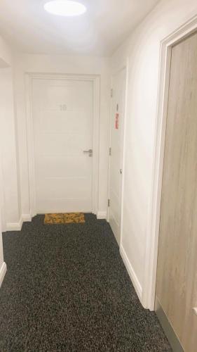 an empty room with a white door and a hallway at Bridgefield Apartment in Ashford