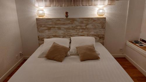 a large white bed with two pillows on it at La Cas'Aline in La Saline les Bains