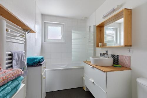 ein Badezimmer mit einem Waschbecken und einer Badewanne in der Unterkunft Les Rochambelles - Maison avec terrasse in 