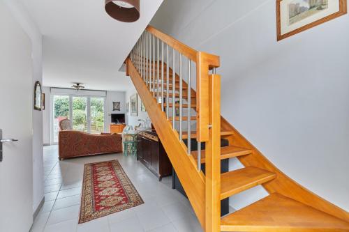 escalera de madera en una habitación con sala de estar en Les Rochambelles - Maison avec terrasse, en Ifs