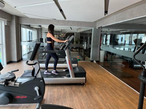 a woman running on a treadmill in a gym at Vidam Hotel Aracaju - Transamerica Collection in Aracaju