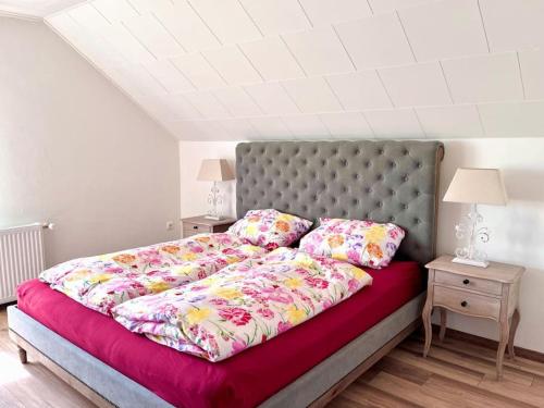 a bedroom with a large bed with pink sheets and pillows at Haus Caroline in Hallschlag