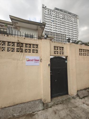 a building with a black door and a tall building at Best Inn Lahug in Cebu City