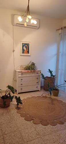 a living room with a dresser and potted plants at Galilean villa with jacuzzi in Qiryat ‘Amal