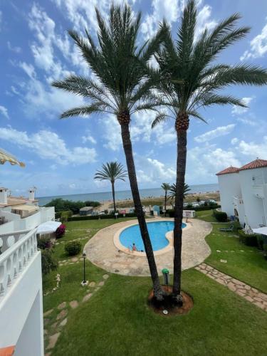 a view from the balcony of a resort with palm trees at Playa Del Sol, 1 dormitorio frente al mar, by Bookindenia in Denia