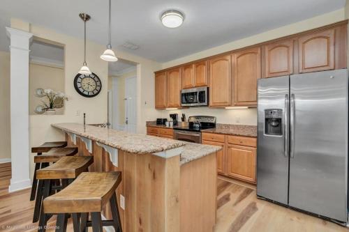 a kitchen with a stainless steel refrigerator and wooden cabinets at The Epic Lisbon Vista Cay Orlando in Orlando