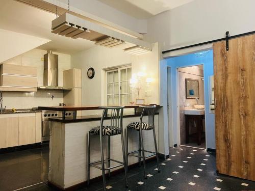 a kitchen with two bar stools at a counter at Monica’s Apartments in Canning