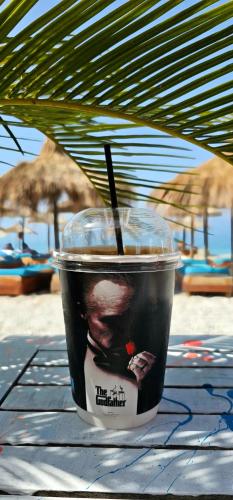 a drink in a plastic cup sitting on a table at Luna Mare Boutique Seaside in Borsh